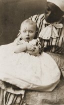 Black woman holding white infant